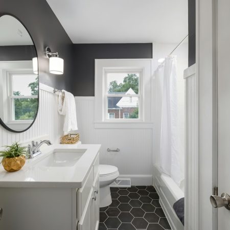 Black-hexagon-floor-tiles-Black-accent-wall-white-tub-and-Vanity-Black-oval-mirrior-topaz-upscale-2.1x-scaled.jpg