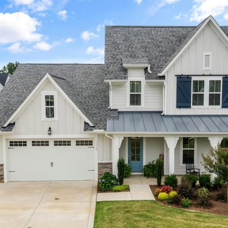 Light-taupe-exterior-board-batten-blue-door-barn-sytle-slide-shutters-scaled.jpeg
