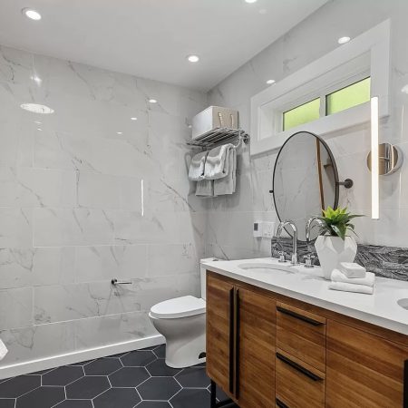 Natural-wood-vanity-black-round-mirrors-white-shower-tile.jpg