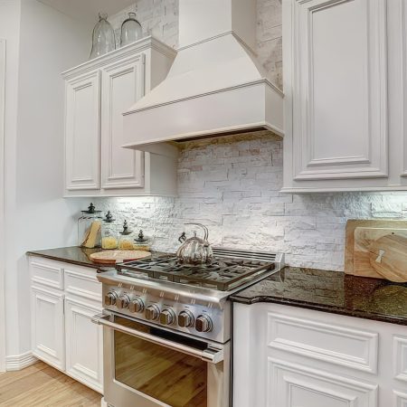White-cabinets-white-stone-backsplash-gas-range-scaled.jpeg